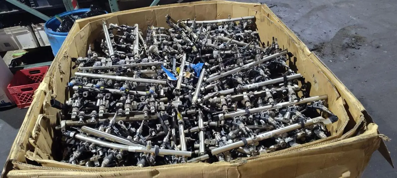 Wooden warehouse bin holding grouped small used automotive components and shafts